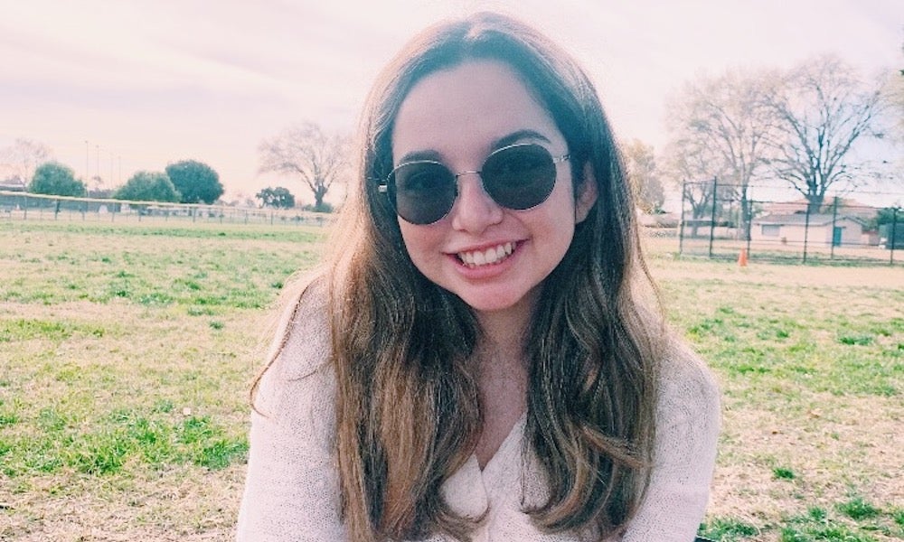 Laura poses in a field wearing sunglasses at UC Davis. 