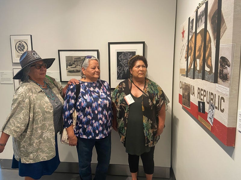 Native women viewing image of California flag artwork in Gorman Museum UC Davis