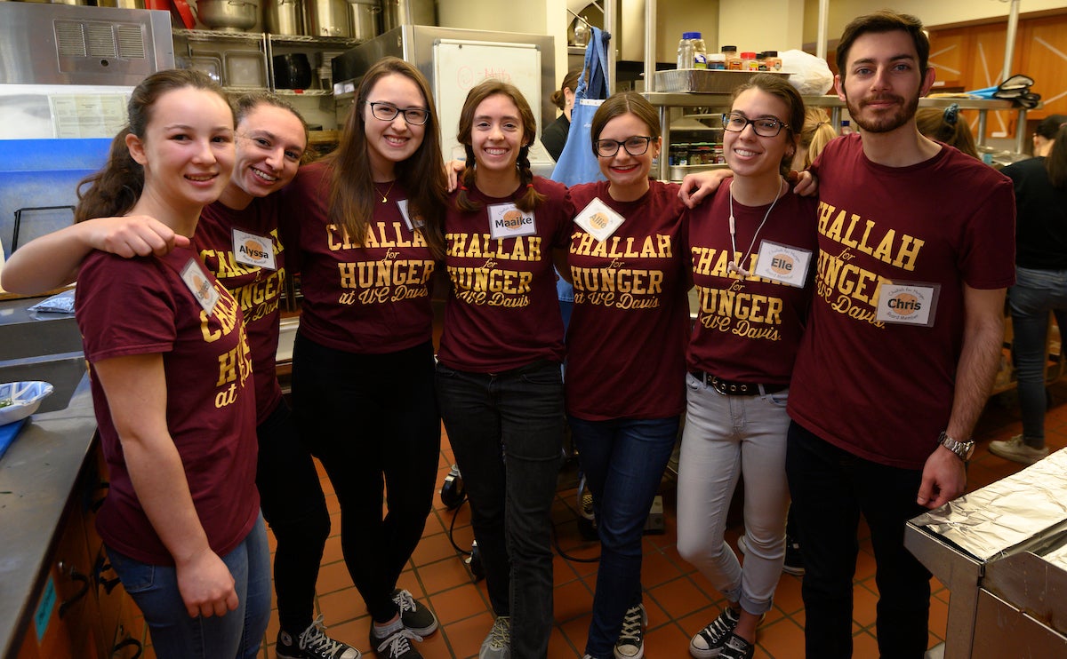 Volunteers smile and pose in a kitchen at UC Davis.