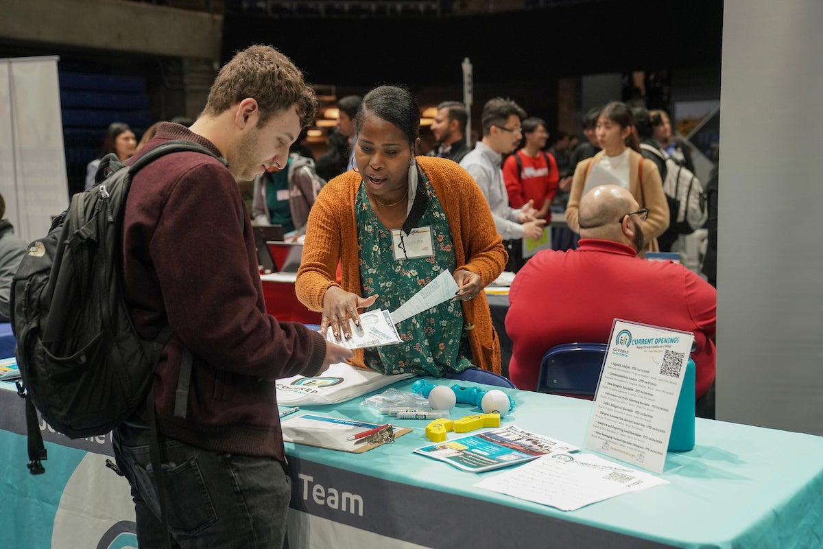 A student talks to a potential employer at a booth at UC Davis.