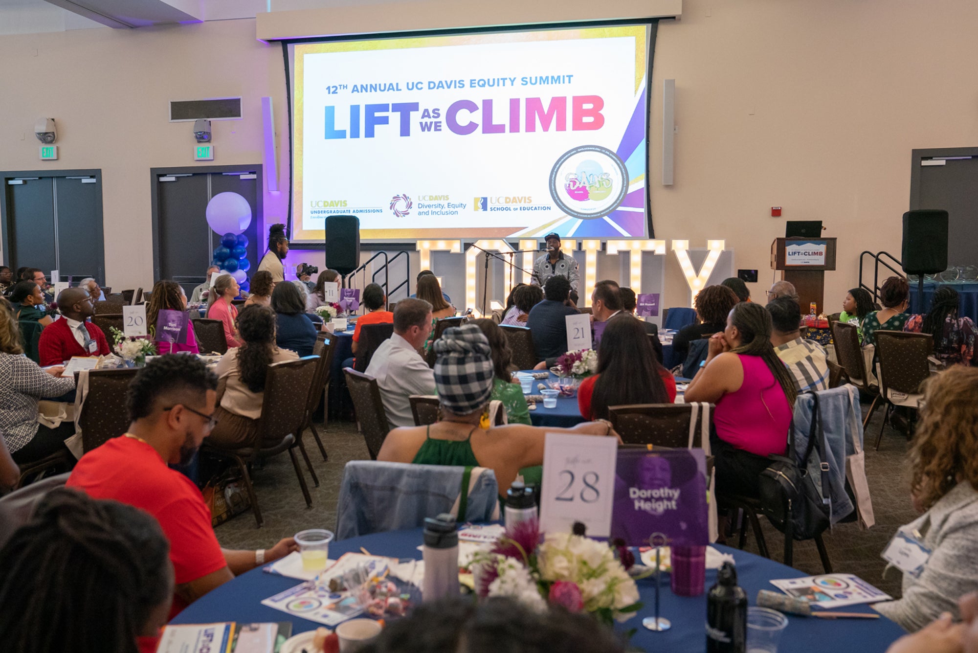 Equity Summit overview, with "Lif As We Climb" projected on screen, and "Equity" spelled out in latters on the stage