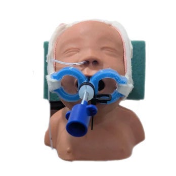 Medical training mannequin head with blue airway device and white straps on green headrest