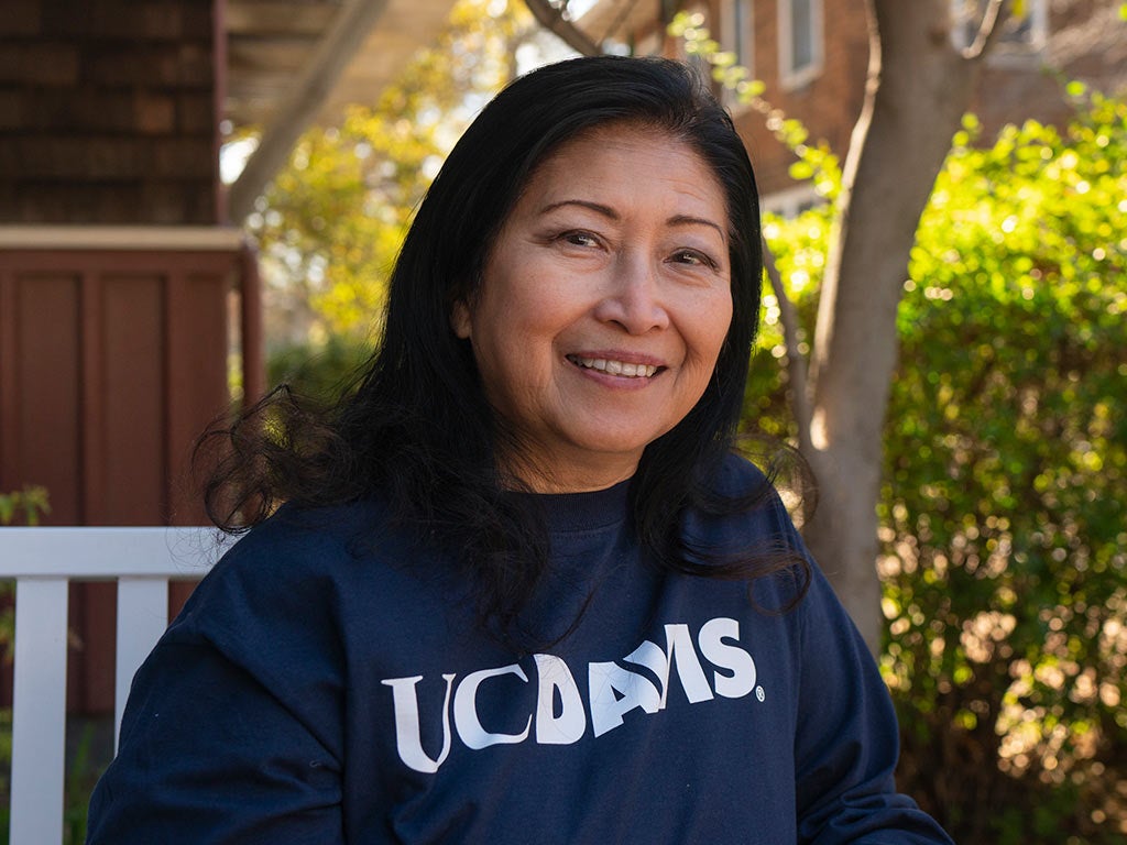 A photo of Mary-Ann Meyers smiling on a bench on the UC Davis campus