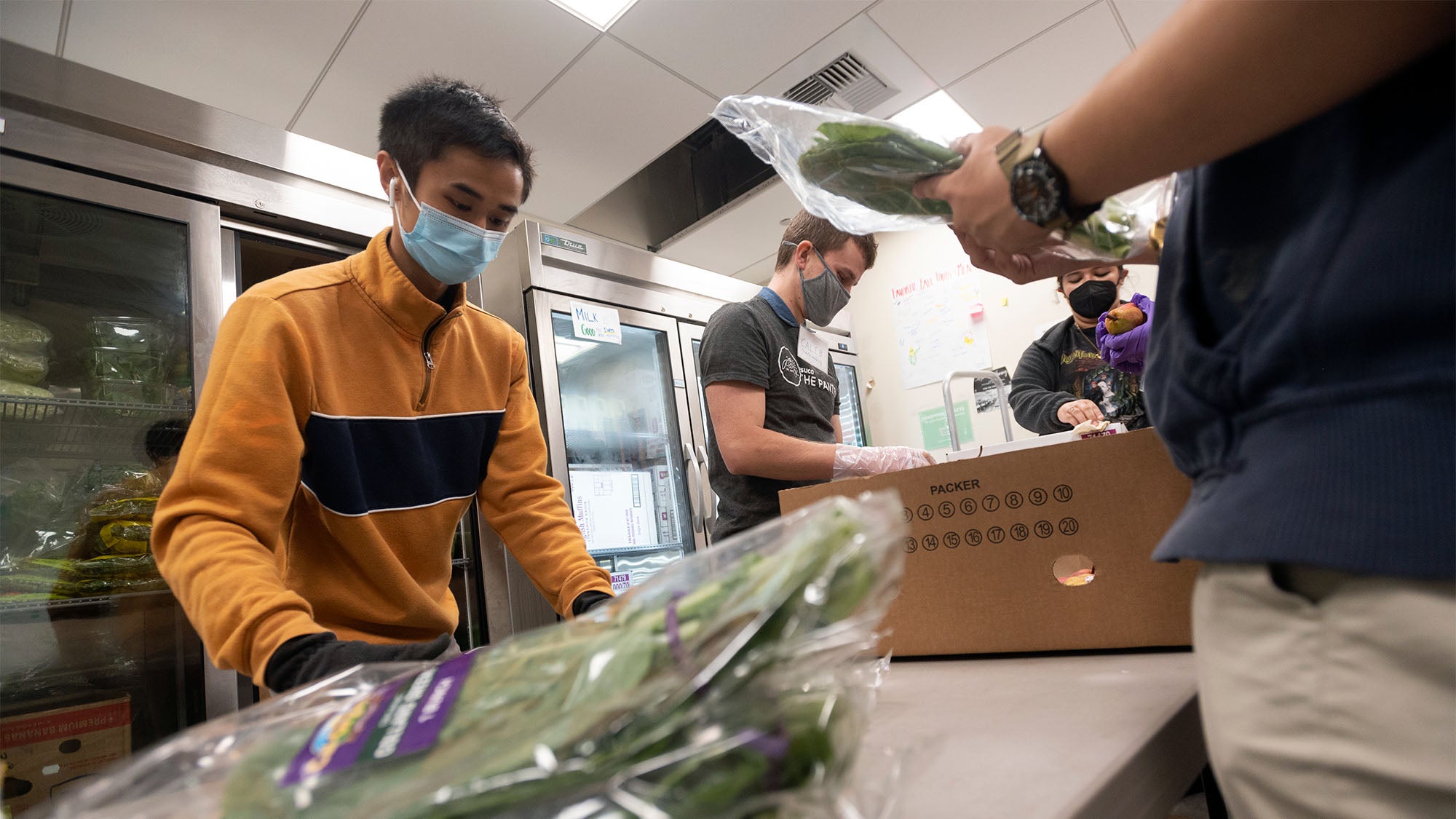 Students prepare vegetables for distribution at The Pantry.