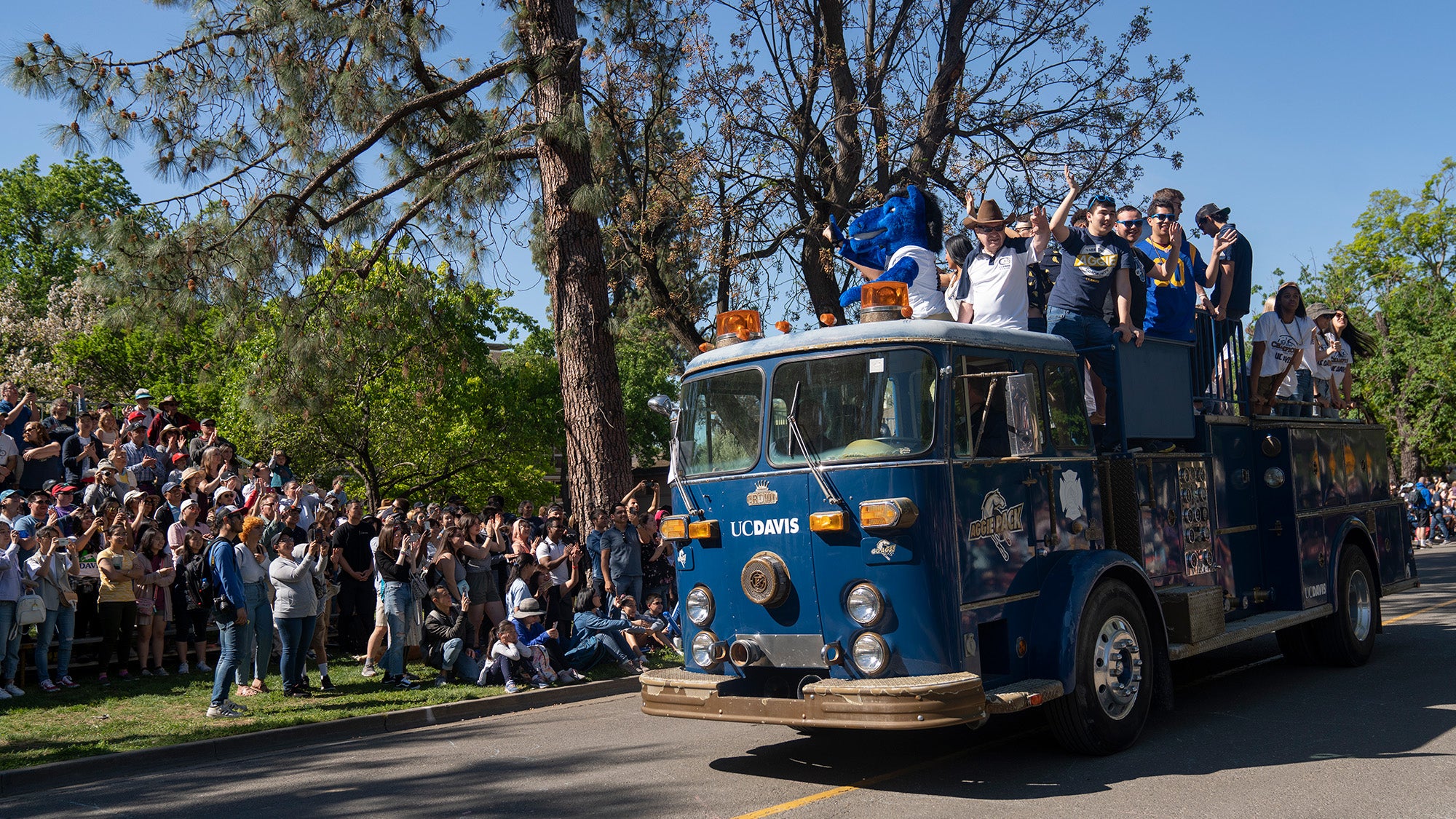 People watch a fire truck drive by during a Picnic Day parade.