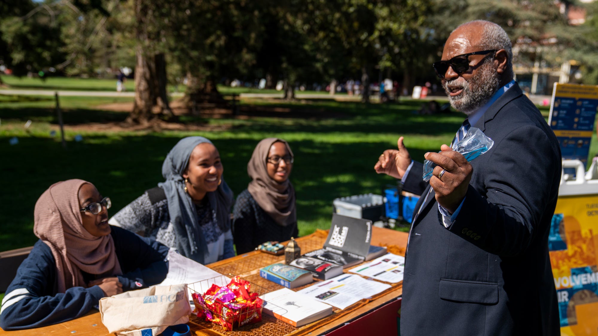 Rahim reed visits students who are tabling on the Quad.