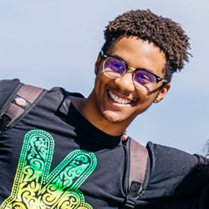 Young man, smiling, wearing bright T-shirt, from cover of report