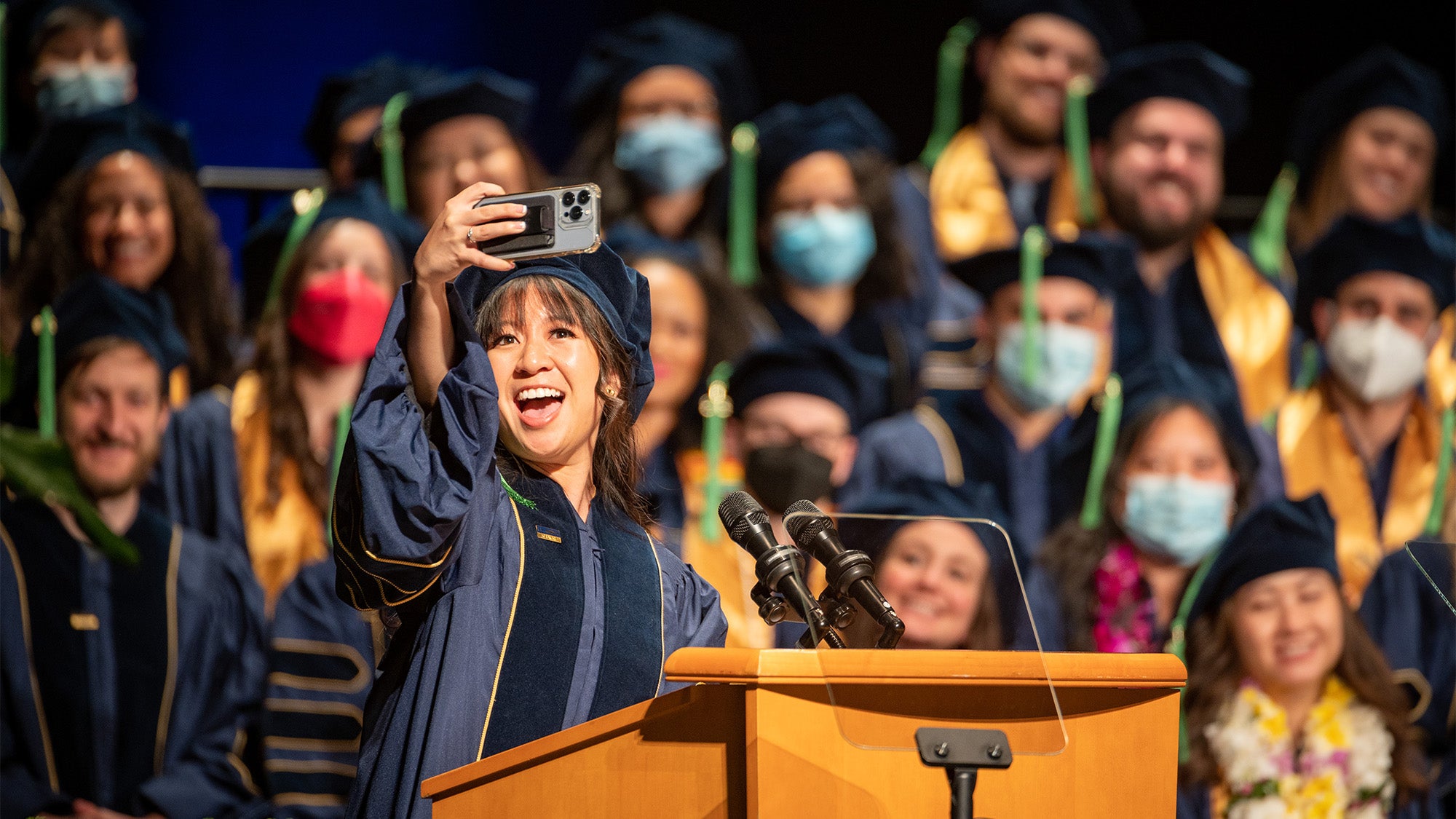 Speaker takes selfie at commencement lectern