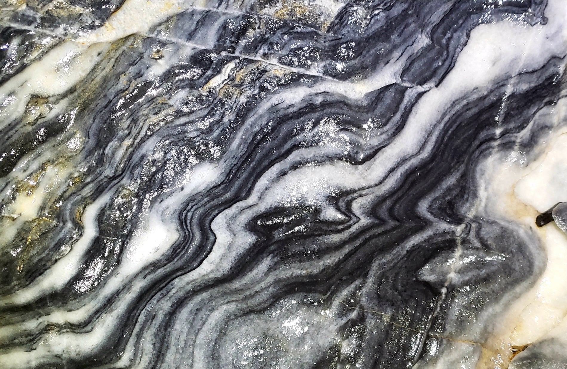 Photo or gray and white striped marbled rock from inside a cave