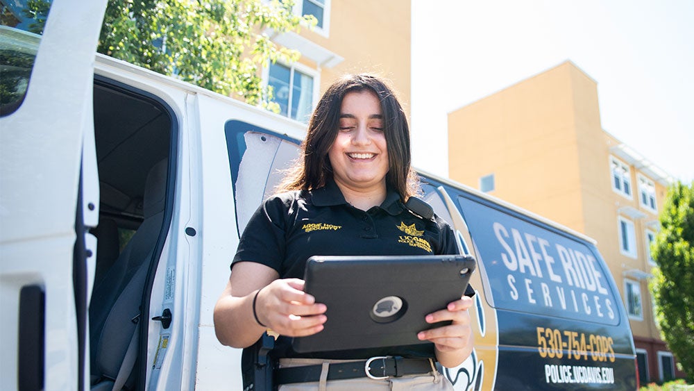 Uniformed woman in front of Safe Ride Services van