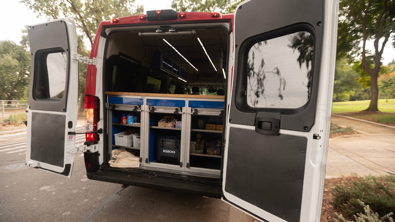 The rear doors of the Health 34 van are open to show its supplies of basic needs items.