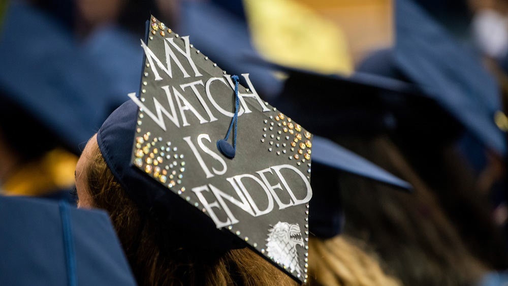 A close up of a grad cap that says "My Watch Has Ended" in a game of thrones reference.