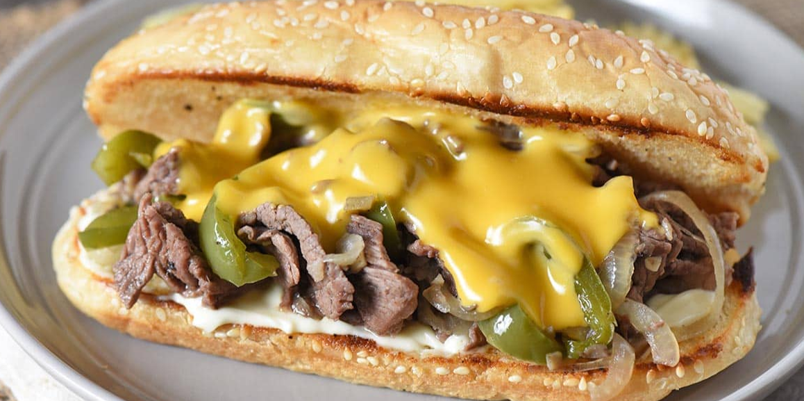 "Ultimate Philly" sandwich: lunch meat, onions, peppers, nacho cheese, on French roll