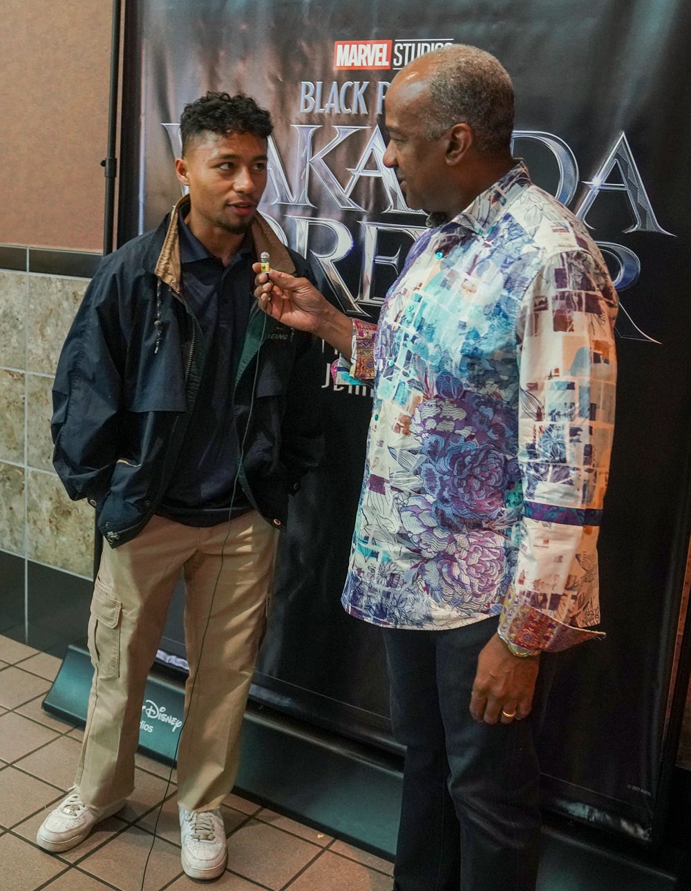 Chancellor May interviews student in front of "Wakanda Forever" poster
