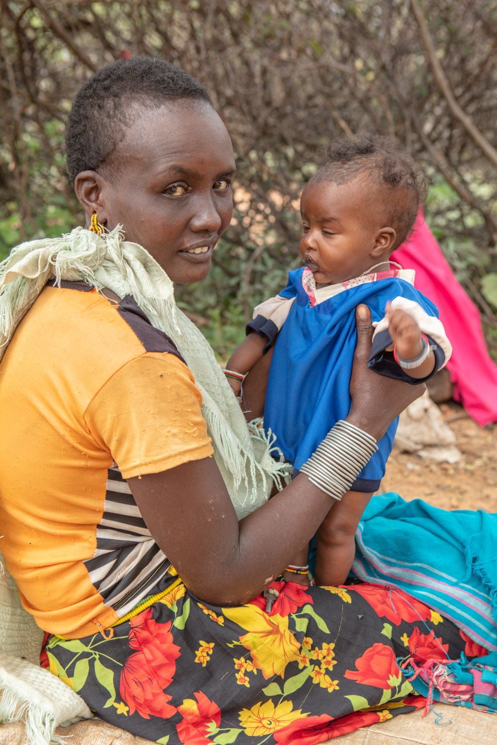 Mother sitting and holding her baby in Samburu, Kenya.