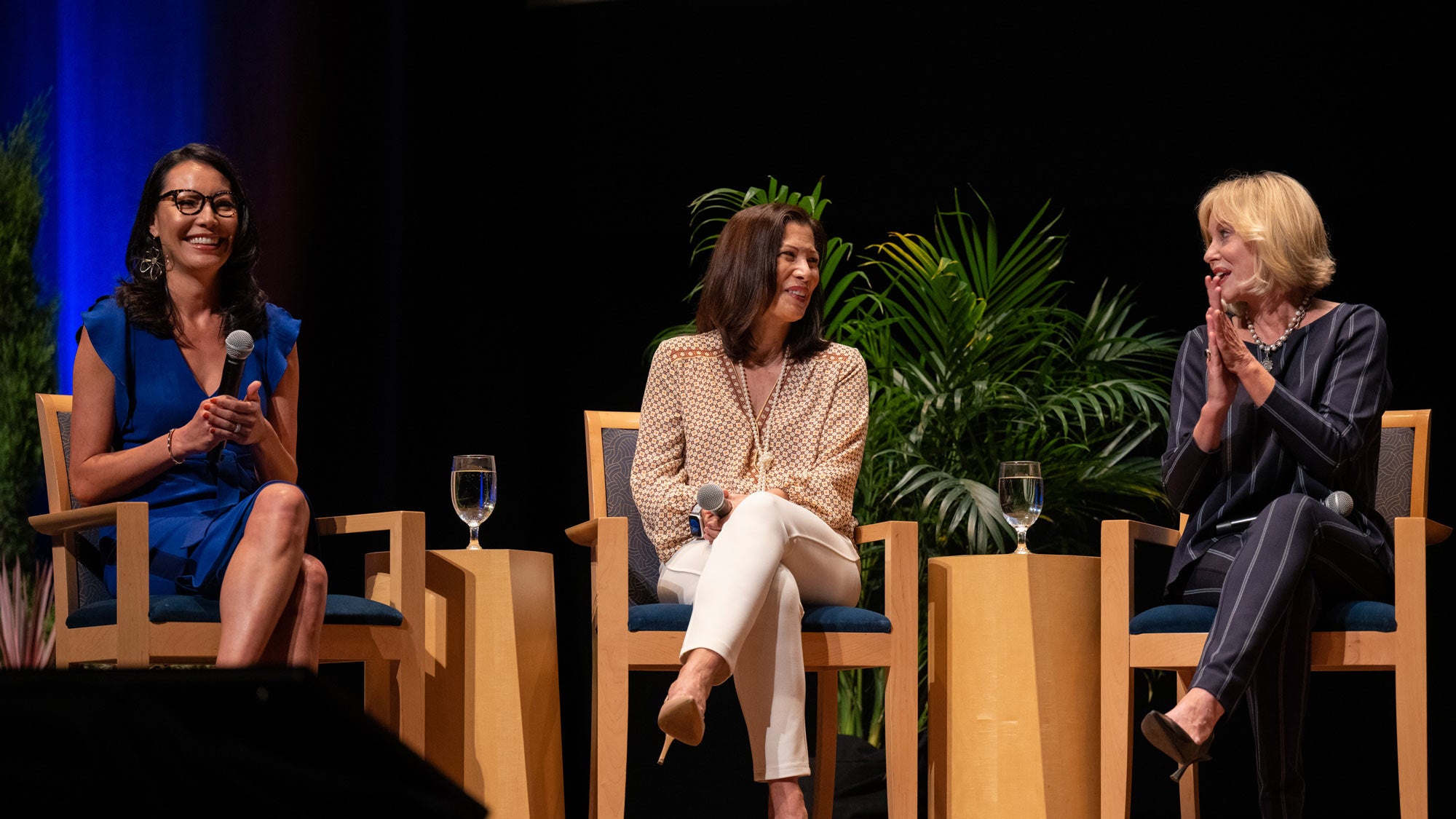 Three female panelists, seated, onstage at UC Davis