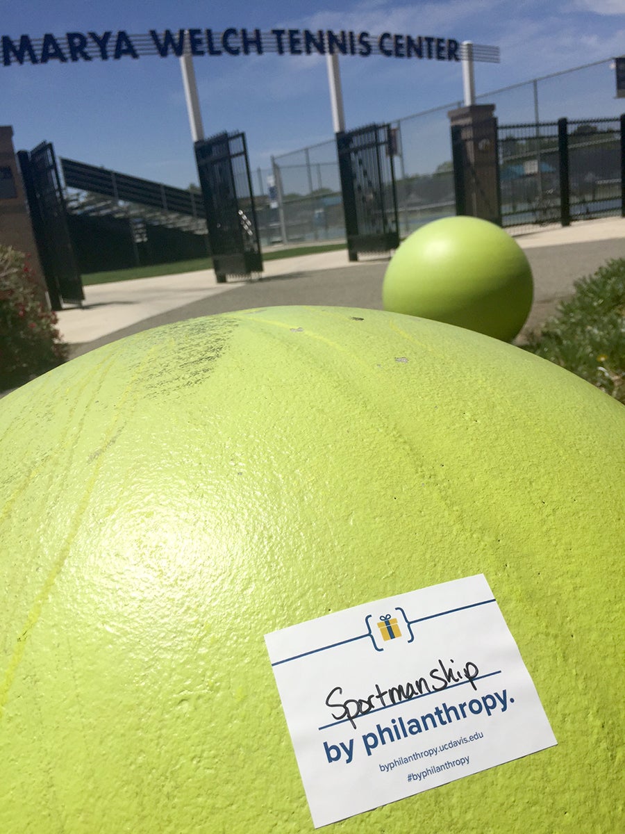 A sticker on the giant tennis ball outside the Mayra Welch Tennis Center reads "Sportsmanship by philanthropy."
