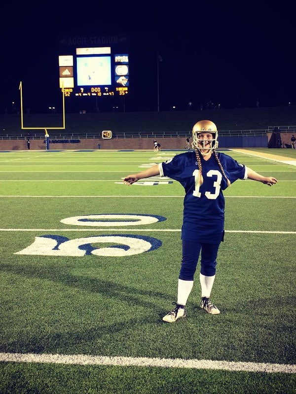  Abby Sutcliffe in football jersey, on the football field.