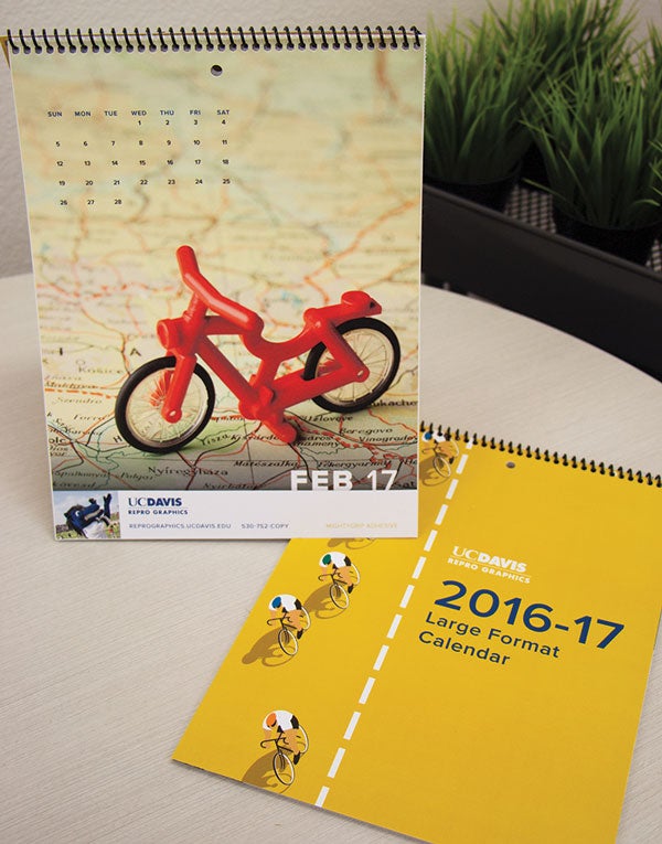 Large-format calendar, with bike toy photographed atop a map