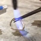A ring being soldered shut.