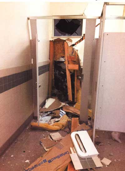 Hole in wall opens into bathroom stall, view from inside.Bathroom stall