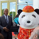 Chancellor Gary S. May and a panda mascot.