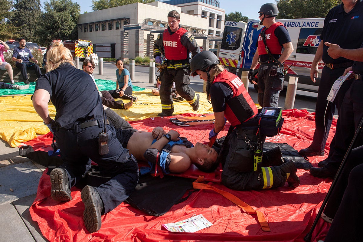 Firefighters administer first aid to mock victims during an active shooter training.