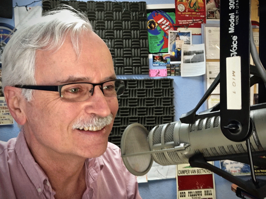 Bill Buchanan talks into microphone, in radio studio