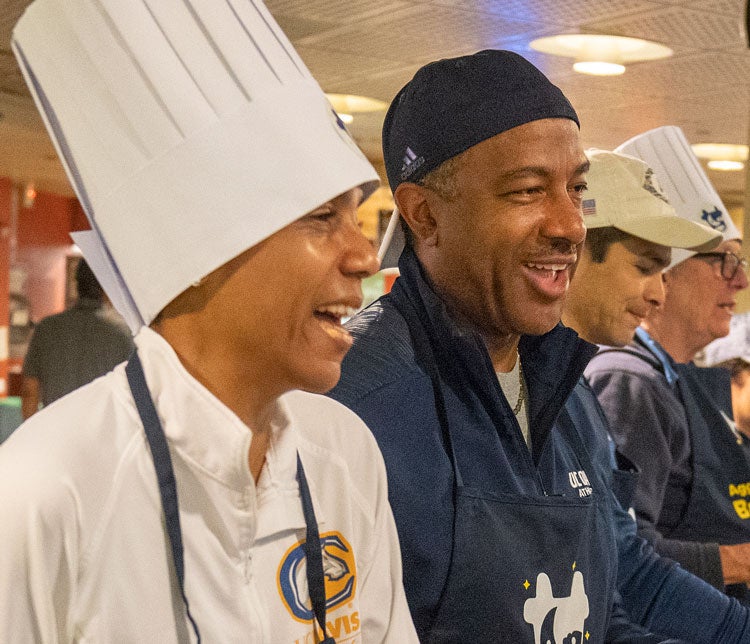 LeShelle May in tall, white chef's hat, and Gary May in baseball cap, serving breakfast.