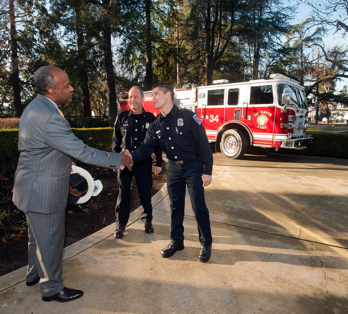 Chancellor Gary S. May shakes the hand of a firefighter.