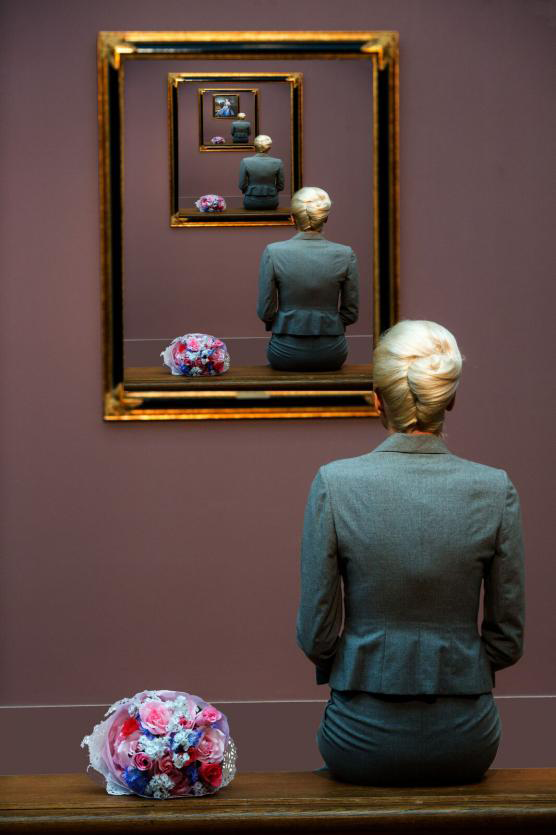 Woman looks into mirror, repeating over and over