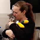 A woman holding and kissing her cat.