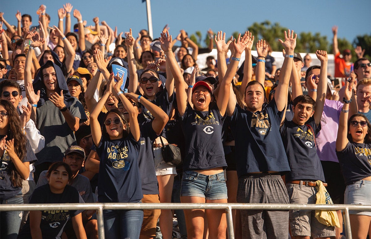 Students cheering during the Homecoming football game.