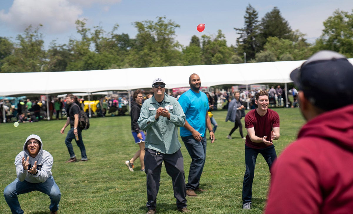 Staff members toss water balloons to each other at the 2018 Thank Goodness for Staff picnic.