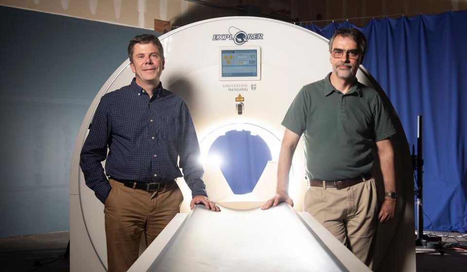 Scientists flank mock-up of new scanner.