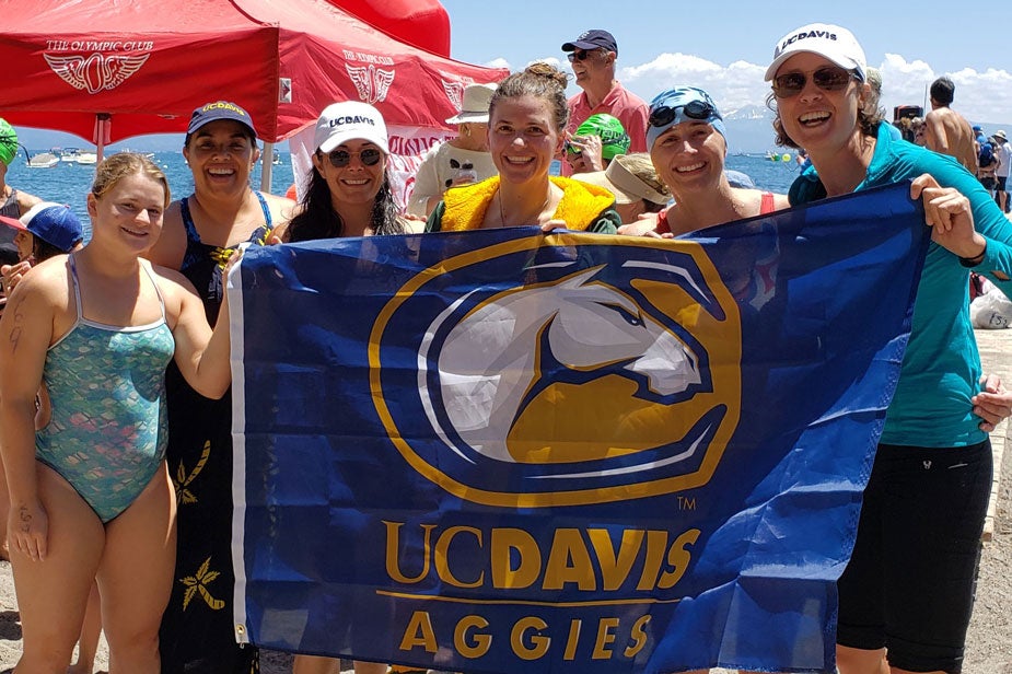 Six women holding UC Davis Aggies Gunrock flag.