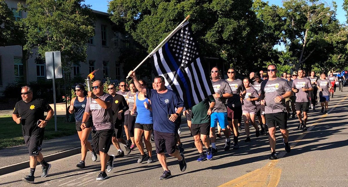 Police officers run with Special Olympics torch.