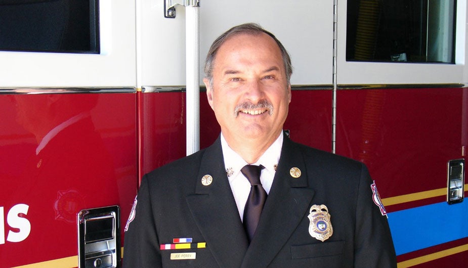 Fire chief in uniform, in front of UC Davis firetruck