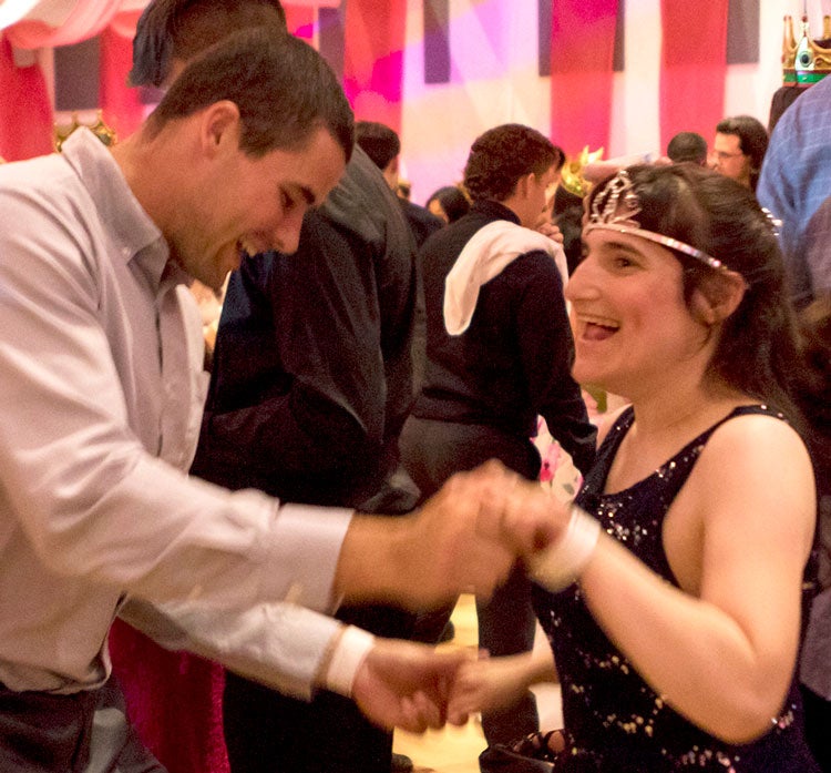 Student-athlete dances with young woman.