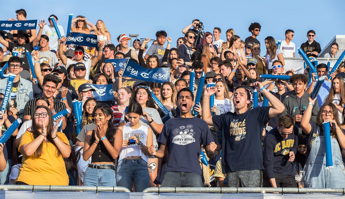 A crowd of students cheering during a football game.