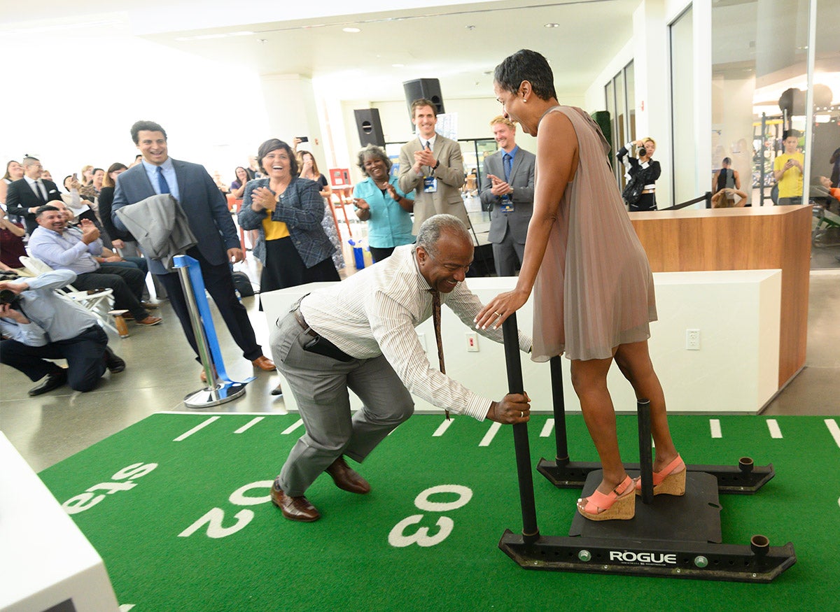 Chancellor Gary S. May pushes a sled with LeShelle May on it.