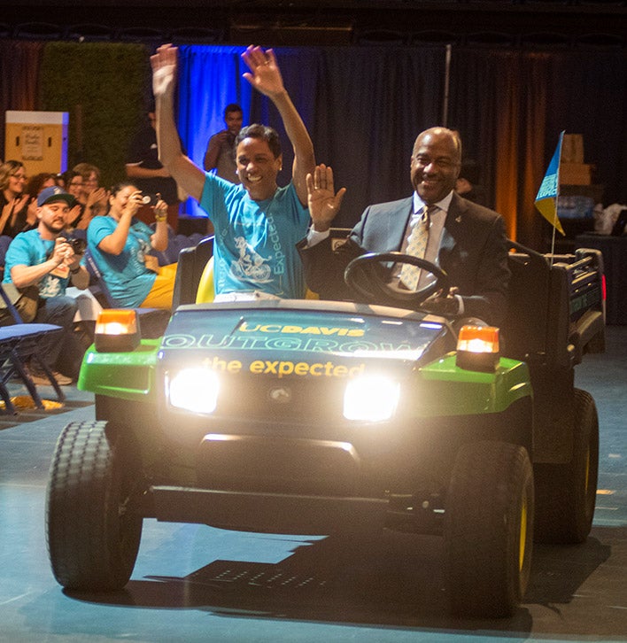 Chancellor Gary S. May and LeShelle May drive into The Pavilion on a Gator.