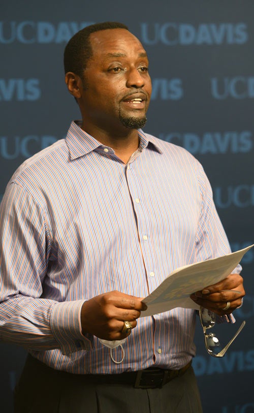 Kayton Carter reading remarks, against "UC Davis" backdrop in broadcast studio.