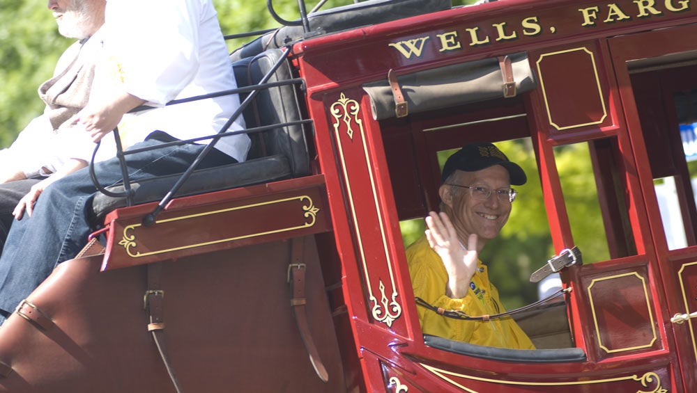 Ken Burtis waves from inside stagecoach during Picnic Day Parade.