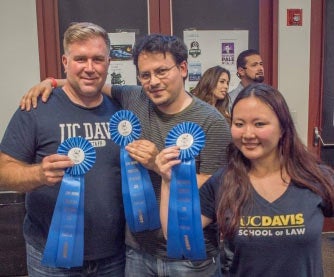 Three people display their blue ribbons.