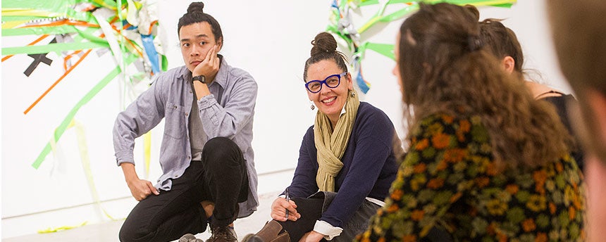 Art studio professor Robin Hill, center, in an art gallery, talking to graduate students