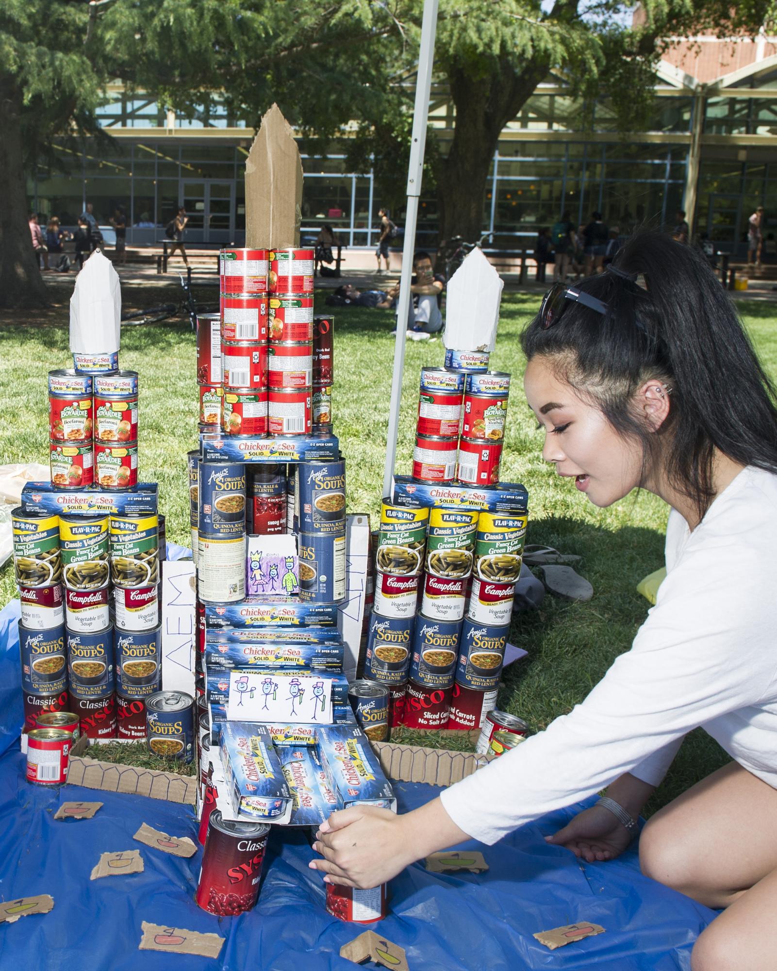 A student stacks canned food in a castle shape