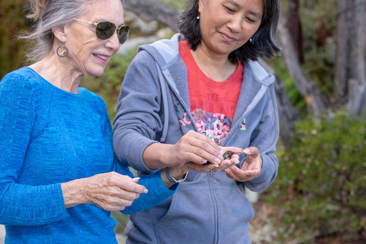 Susan Gottlieb and Lisa Tell, two women hold hummingbird