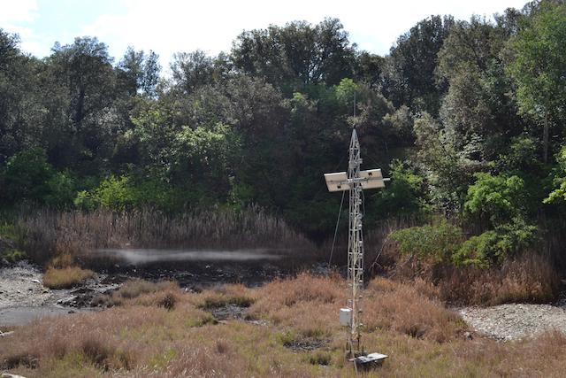scientific equipment in form of tower stands above spring in Italy
