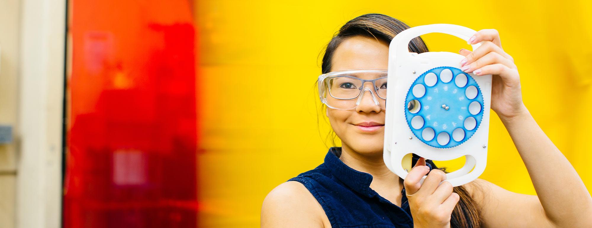 A student poses with her optomalogic invention